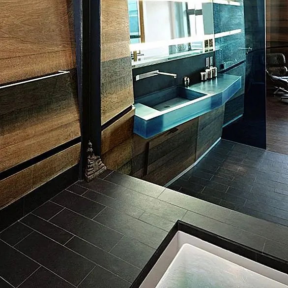 Современный дизайн дополняется кожаным диваном и креслами, а также металлическими аксессуарами, которые здесь и там распространены. Косые окна дают вам прекрасный вид, и все место дышит комфортом и стилем.