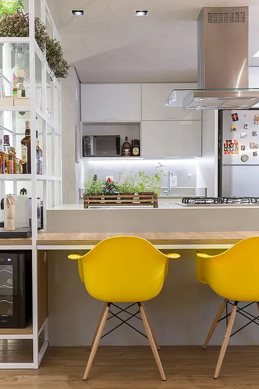 Обеденный стол поддерживается на одном конце действительно интересным делителем. Он доходит до потолочной балки и имеет тонкую металлическую структуру с небольшим количеством индустриального таланта и открытыми полками. На верхней полке большинства полок серия плантаторов придает открытому этажу зеленый и свежий вид, а остальные полки служат своего рода баром, к которому можно получить доступ с обеих сторон.