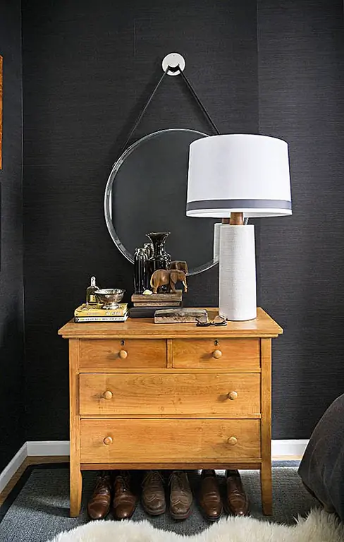 Поскольку комната была крошечной, мебель тоже была маленькой. Несмотря на это, этот компактный комод - идеальная деталь для комнаты. Он нагревает темную и маскулинную палитру.