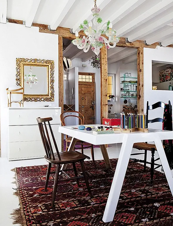 Ковер в деревенском стиле ограничивает рабочее пространство. С другой стороны, письменный стол имеет простой и современный дизайн. Каждый из стульев, которые окружают его, имеет другой дизайн, но все они имеют традиционные функции.