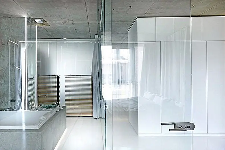 Выбрав стеклянные стены для ванной комнаты, архитекторы сделали ее фактической частью спальни, устраняя сплошные границы между двумя пространствами и позволяя им выглядеть и чувствовать себя больше, чем они есть на самом деле.