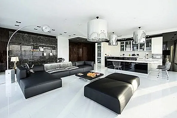 Кухня и гостиная образуют открытый план, и переход от одной функции к другой является гладким и тонким, и все же они хорошо разграничены. На кухне есть белая мебель, установленная на темном фоне, а в гостиной вы можете найти черную мебель, контрастирующую с белым полом и стенами.