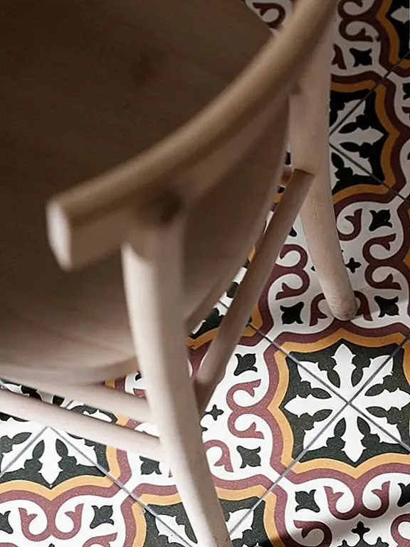 Просторный зал ведет к гостиной, а большие двери создают ощущение открытого пространства. Жилая площадь имеет необычную форму, с изогнутыми стенами, и эту форму подчеркивали, разместив круглый коврик в центре комнаты. Осветительная арматура - это сфера, которая также призвана подчеркнуть архитектуру комнаты. Камин - привлекательный элемент здесь.