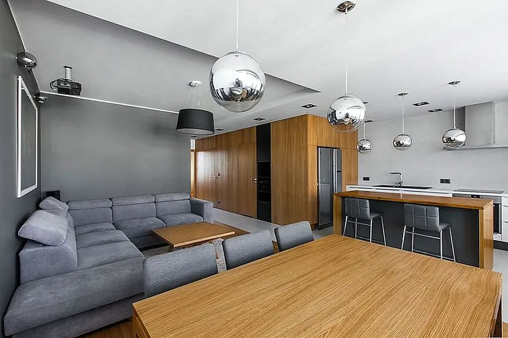 Вуд был выбран в качестве основного материала. Как обычно, древесина добавляет тепла к декору, что делает его приятным и уютным. Это также дает элегантность квартиры, не делая ее слишком трезвой. Большой стенной блок в гостиной - главная особенность всей социальной сферы.