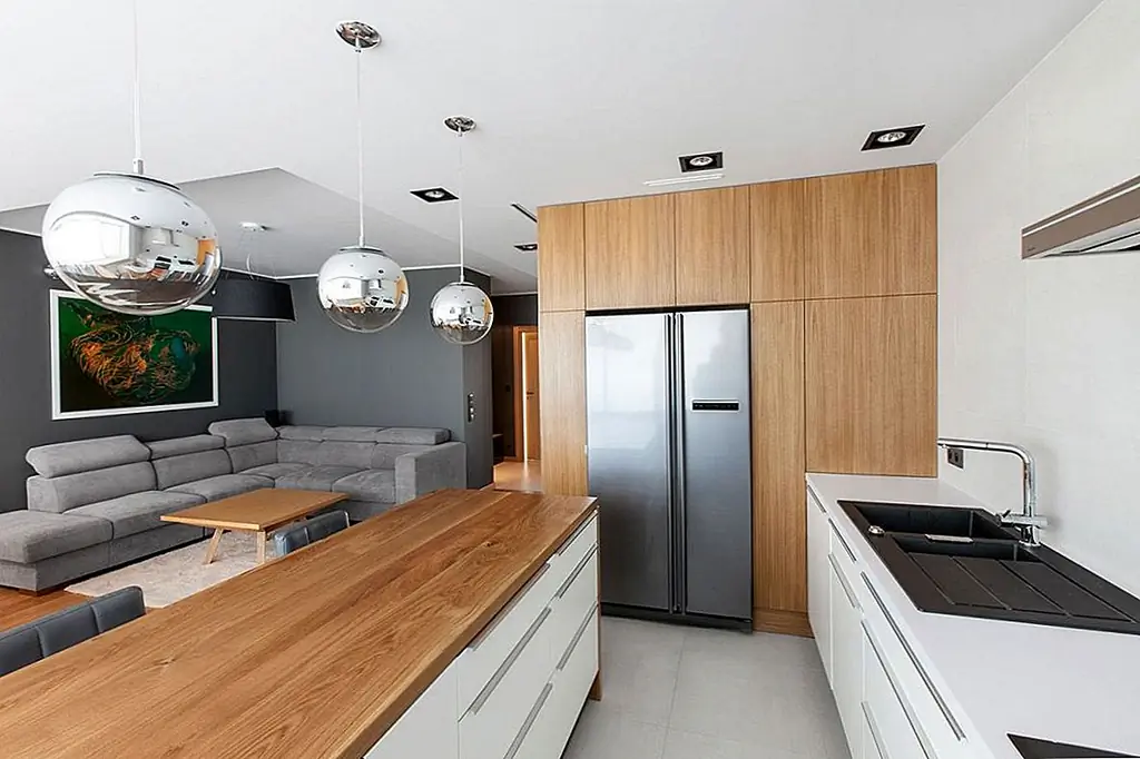 Этот блок предлагает много места для хранения, а также вмещает несколько кухонных приборов, таких как холодильник, который был встроен в сторону устройства.