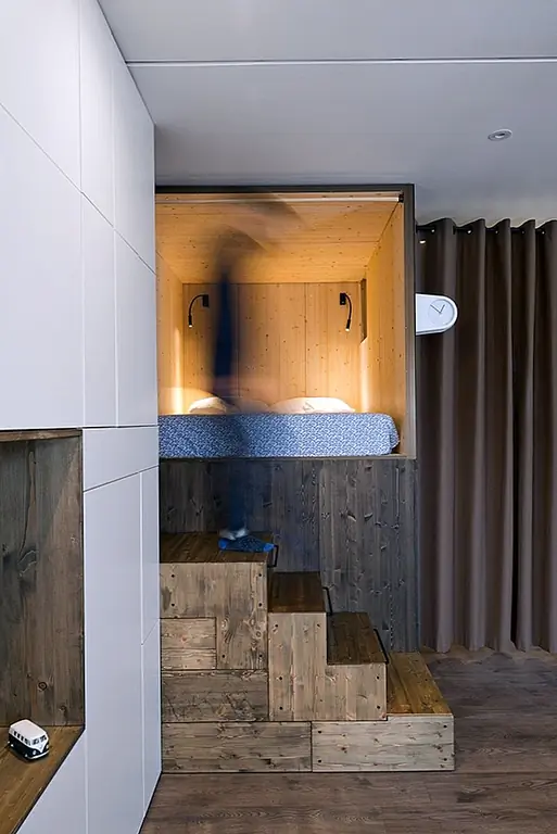 Клиенты попросили дизайнеров превратить небольшую квартиру в комфортабельный дом с открытым пространством и достаточным количеством пространства для хранения и естественного освещения. Чтобы соблюдать эти требования, дизайнеры должны были быть творческими. Вместо разделения пространств с твердыми стенками они выбрали шторы для более гибкой и компактной конфигурации.