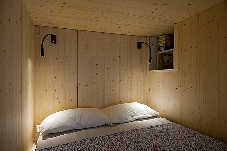 Из угла спального уголка открывается прекрасный вид на всю квартиру. Коробка построена из окрашенных сосновых листов и предлагает очень уютную, теплую и уютную атмосферу внутри. Коричневый занавес отделяет его и кухню и жилую площадь от входного пространства. Живая и обеденная зона - это гибкое пространство. Обеденный стол расширяется и вмещает до 10 человек, а диван - достаточно легкий, чтобы его можно было перемещать.