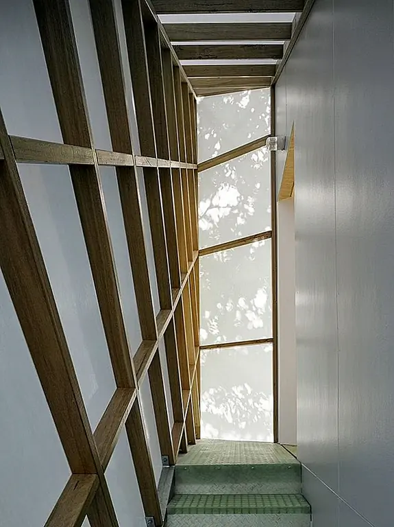 Земельная стена открывается на веранду и в тесной связи с садом и, в частности, с большим деревом, которое стоит рядом с ним, как опекун. Наверху есть пространство на чердаке, с одной областью, служащей офисом. Пользовательский стол был построен, чтобы поместиться в углу и перед большими окнами.