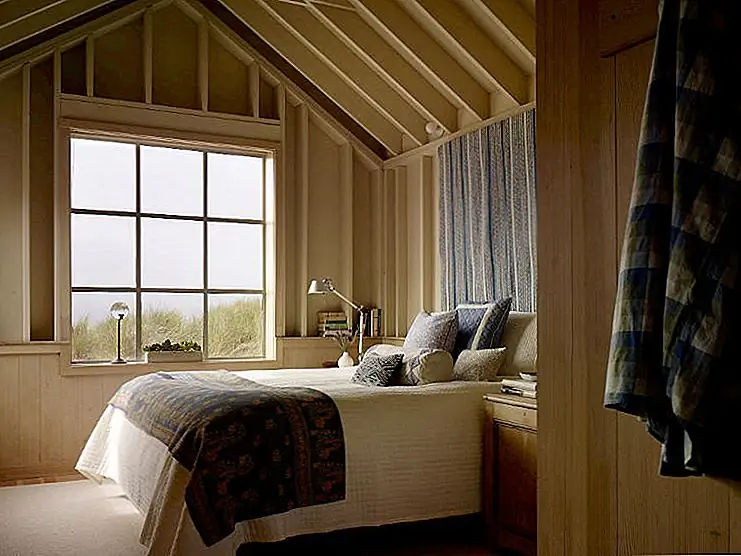 В гостиной есть плетеные предметы мебели и современный камин, из которых можно отдохнуть в расслабляющей зоне. Столик обеденный простой и теплый, сделанный из того же дерева легкого нюанса, как и его стулья. Деревянная стена отделяет зону обеда от кухонной зоны.