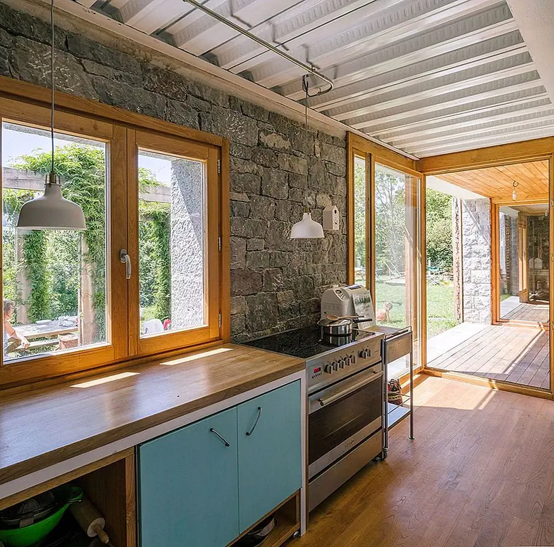 По всей длине здания была построена большая трехместная гостиная. Он имеет окна с глубокими утопленными и большими деревянными жалюзи, спроектированными так, чтобы напоминать двери сарая. Все внутреннее пространство организовано вокруг четырех ромбовидных структур, которые движутся вертикально, хотя дом.