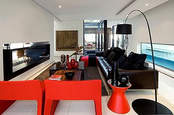 Жилая комната на самом деле меньше, чем ожидалось. Это только одна часть социальной области, и у нее есть удобный кожаный диван с соответствующим коричневым ковриком, минималистским напольным светильником и контрастными красными креслами. В отеле также есть современный камин, который придаёт декору особый стиль.