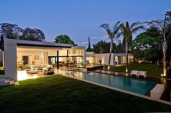 Дом с угловым современным камином и раздвижными стеклянными стенами