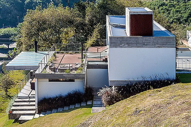 Участок, на котором он стоит, имеет крутой склон, следовательно, проблемы, о которых мы говорили. Архитекторы решили обнять склон и построить дом на двух основных этажах, верхний - самый впечатляющий. Прихожая находится на промежуточном уровне и имеет стеклянный потолок, который позволяет в большом количестве естественного света в течение дня и предлагает действительно прохладный вид на небо ночью.