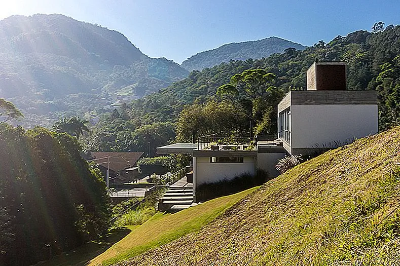 Современный дом обнимает прочный ландшафт и делает большую часть его