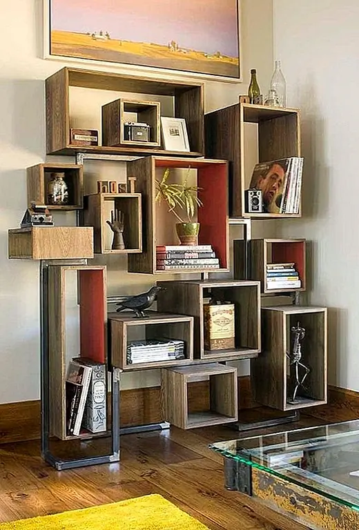 Но это не единственная интересная часть дома. Фасад здания так же замечателен. Каменная дорожка ведет к входу, и оттуда вы можете увидеть такие элементы, как дерево, камень и металлические черты, которые повторяются по всему дому. Цилиндрическое фойе ведет в социальную зону. Он выставил балки, каменную стену и красивый камин. Также есть светильник, идентичный светильнику в фойе, и он подвешен над зоной отдыха, которая включает в себя стул, подвешенный к потолку.