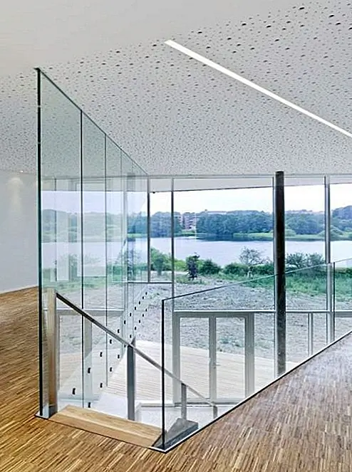 Дом почти кубической формы и имеет компактный, но открытый и легкий дизайн. Большие окна и стеклянные стены захватывают чудесные виды и соединяют внутренние пространства с природой. Передняя часть дома полностью открыта наружу, а на первом этаже есть небольшая колода, которая делает переход более естественным. Большинство внутренних стен сделаны из стекла, что придает интерьеру очень открытый и воздушный вид. Комнаты визуально связаны друг с другом, и свет проникает сквозь стены и вторгается в весь дом.