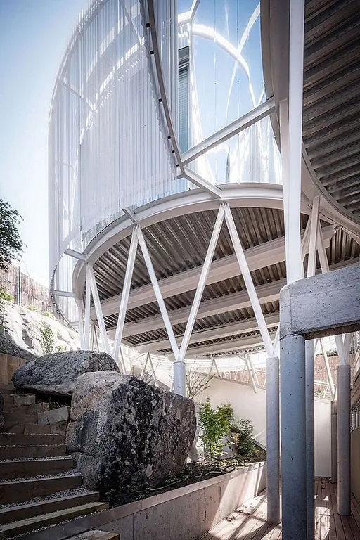 Большая пустота отделяет его от верхнего уровня. Пустота содержит вход, автостоянку и две лестницы.