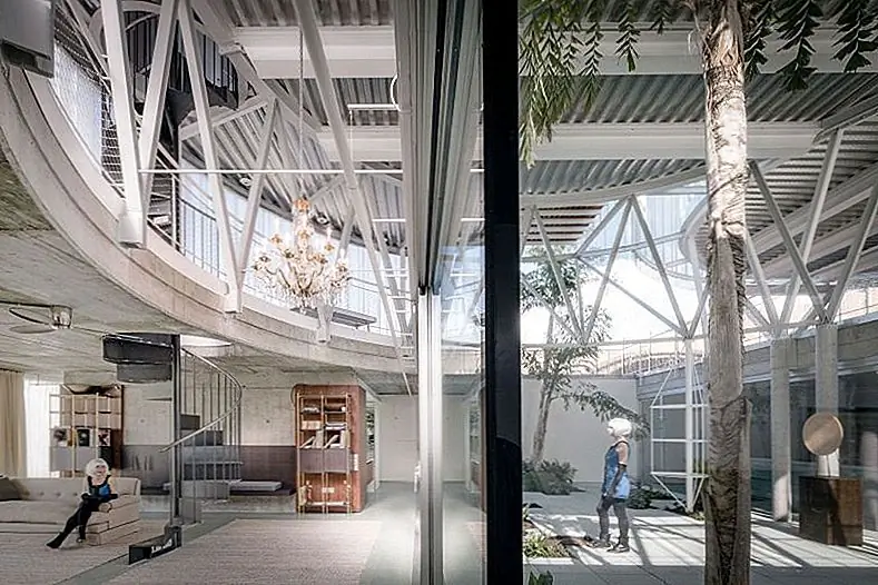 Верхний уровень - это объем с двойной высотой. он состоит из трех пустых цилиндров, обернутых гофрированным железом. Три цилиндра вмещают в общей сложности девять комнат. Здесь находятся частные функции дома.