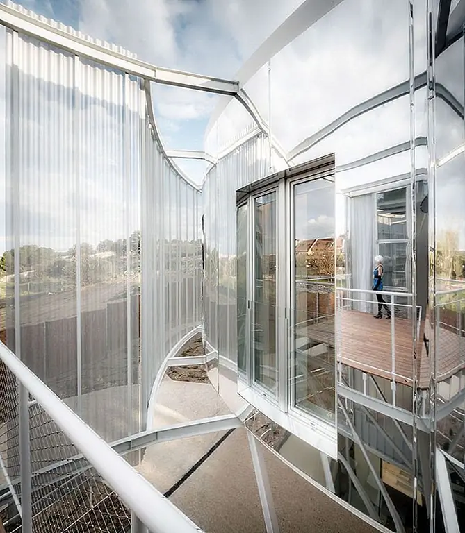 Длинные занавески скрывают интерьер как на земле, так и на верхнем этаже, создавая уютную и интимную атмосферу внутри дома. Два сада, один спереди и один сзади, соединяют внутренние пространства с природой элегантным и элегантным способом.