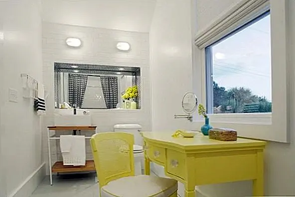 Это во многих отношениях классический декор для ванной комнаты. Он имеет белый потолок, белые стены и белый пол. Однако есть что-то очень случайное и приглашающее. Прежде всего, у него есть тщеславие и стул. Они имеют сходные стили и имеют желтую отделку. Основной причиной установки этой детали было то, что большое окно с видом на город. И поскольку этот предмет мебели занимает много места, остальная часть ванной очень проста. У раковины очень интересный дизайн. Он сидит на каком-то хранилище с открытым отсеком внизу и полотном для полотенец спереди. Опять же, зеркало усиливает пространство и создает разнообразие.