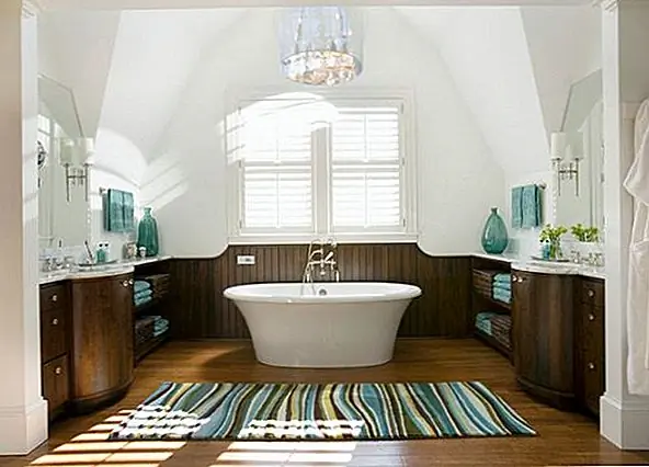 Дерево - это материал, который добавляет тепла везде. Это позволяет нам чувствовать себя ближе к телу, и его текстура очень красива. Технологические усовершенствования теперь позволяют нам также использовать этот выдающийся материал в ванной комнате, и результаты впечатляют. Для этой ванной комнаты центральная часть - это ванна, а окружающие стены покрыты деревянными панелями и деревянными блоками хранения. Аналогичную ванну можно найти в Bunnings Warehouse. Остальная часть декора минималистская и полностью белая. Сочетание цветов очень шикарно, а синие акценты - это детали, которые делают эту ванную настолько стильной.