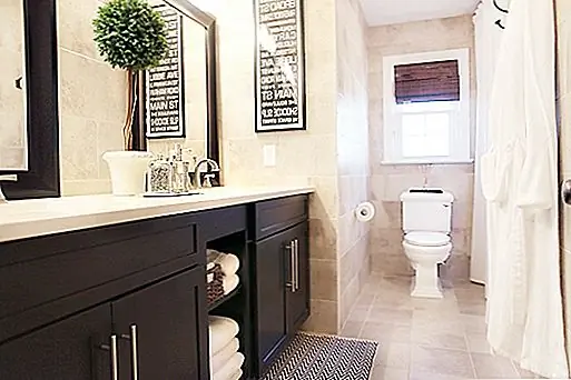 Искусство темной стены, которое было составлено из улиц вокруг города, контрастировало с светлой и светлой черепичной стеной. Все было выбрано, чтобы воплотить в жизнь идею элегантности и комфорта. Напротив тщеславия были использованы два масляных потертых бронзовых крючка, открытые стеллажи посреди тщеславия, небольшая плетеная корзина, чтобы загорать мочалки, а для держателя туалетной бумаги использовали сатиновый никель, чтобы соответствовать другим аксессуарам.