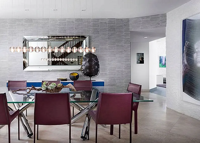 Успокаивающие кожаные обеденные стулья из мерло-цветного дерева добавляют уникальный облик этого современного столового пространства. Изображение: AGSIA Design Group