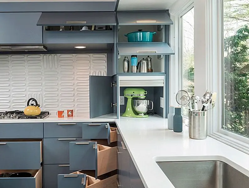 Скрытый прибор гаража скрывает мелкие, повседневные предметы и бытовую технику. Углы сложны в использовании, поэтому дизайнер установил угловые ящики для серебра, специй и многое другое. Изображения: Flavin Architects