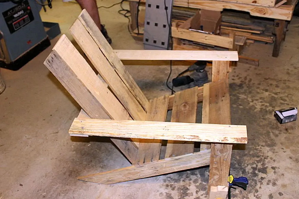 Интересным вариантом является использование восстановленной древесины поддонов для строительства стула Adirondack. Это то, что предлагает этот учебник из инструктивных материалов. Как вы можете видеть, дизайн очень прост, и это может быть довольно легко завершить проект без каких-либо проблем. Вот что вам нужно для этого: сверло, пила, хомуты, наждачная бумага, винты и дерево поддонов. Если вы хотите, вы можете нарисовать дерево, но нам действительно нравится его естественная отделка, поэтому подумайте о том, чтобы оставить его как есть.