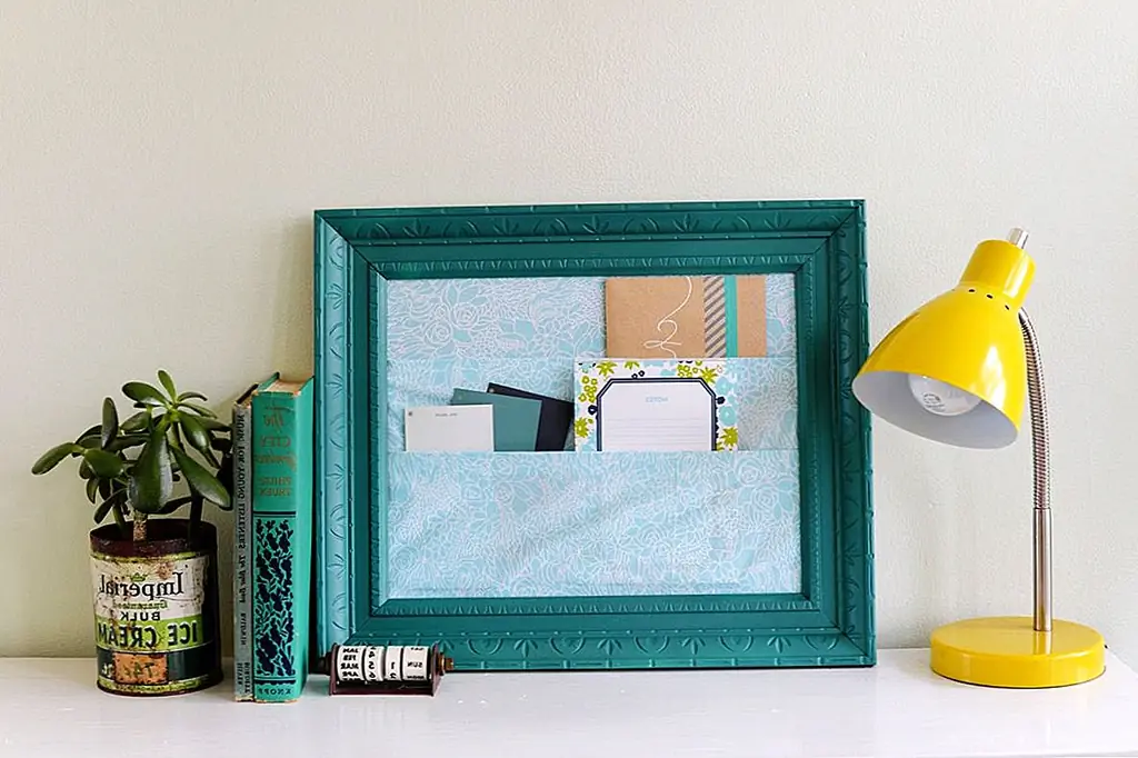 У нас также есть симпатичная идея проекта для тех из вас, кто не получает много почты, но все же хочет сортировать ее стильным и элегантным способом. Посмотрите этот организатор ткани в рамке. Это сделано с использованием старой фоторамки, которая была нарисована. Стекло было снято, а картонная коробка была снабжена тканевыми карманами. Поместите это на полку или на консольный стол или, если вы хотите сэкономить место, установите его на стену.