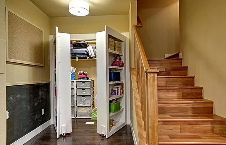 Рассмотрите этот вариант, если вы хотите скрыть кладовку или складское помещение. Допустим, комната выходит из коридора. Вы можете заменить двери функциональными стеллажами. Таким образом, вы также получите дополнительное хранилище. Идея также работает для подвальных помещений. {Найден на готовом основании}.