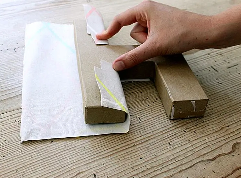 Используя вашу кисть, закройте часть буквы, которую вы только что нарезали на ткань с помощью Mod Podge, а затем наложите на нее ткань, потянув ее и обмотав вокруг всей буквы.