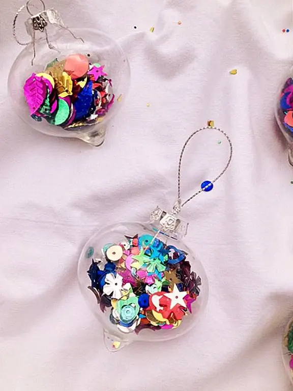 Прикусите немного недорогих пластиковых, шариковых украшений в местном магазине и начните креатив. Сделайте свой собственный конфетти или купите в магазине кучу разных видов праздничных билдов, затем попросите их заполнить их и повесить на дерево! Это довольно забавный и игривый вид. {Найден на happylittlekiwi}.