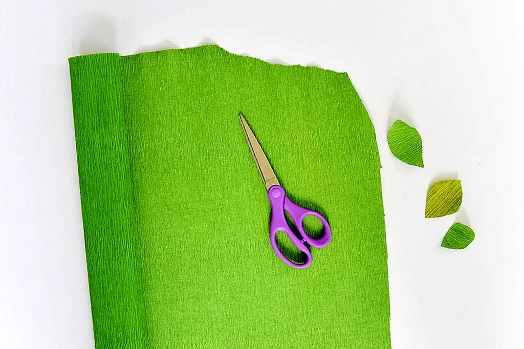 После того, как вы найдёте несколько ветвей (вы, на заднем дворе, - отличное место для начала, ищите ветви, которые естественно падают и высыхают, таким образом они не будут меняться со временем), вырезать листья. Вы можете использовать различные толщины крепированной бумаги, а также различные оттенки зеленого. Для этого проекта у нас была какая-то крепированная бумага, которая была освещена и несколько поблекла. Это привело к небольшому градиенту в листьях, который выглядел очень естественным. Если у вас нет выцветшей крепированной бумаги, другой способ добиться этого градиента состоит в том, чтобы использовать немного прозрачной воды, чтобы вытечь из крепированной бумаги или краски с водяным краском, чтобы добавить более темный оттенок. Когда вы разрезаете свои листья, нарежьте их слоем в крепированной бумаге, идущей вертикально. Вырезать листья в различных формах, все немного разные. Резка складок по вертикали позволит вам раздвинуть лист и манипулировать им, привязывая его к ветвям, чтобы листья выглядели более органично.