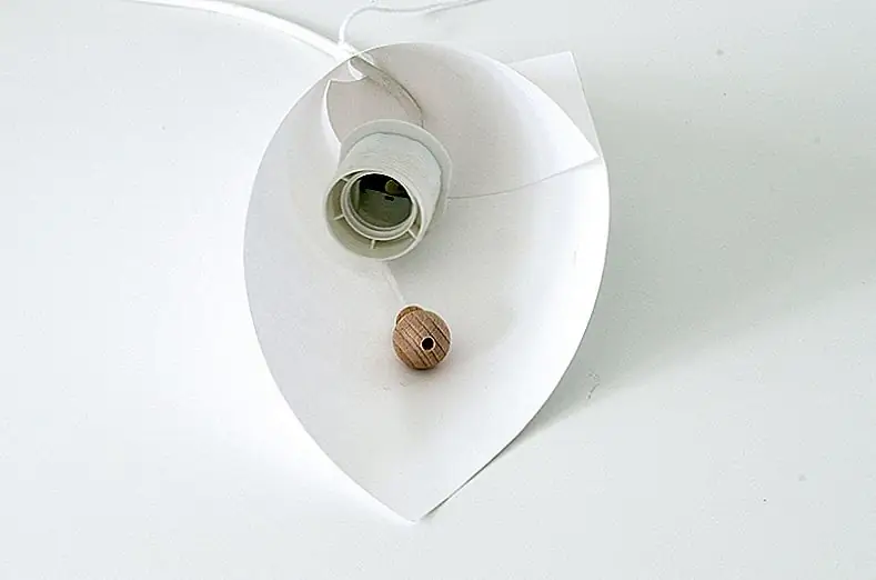 6. Проденьте веревку через верхнюю часть конической лампы и добавьте бусины в конце ее. Убедитесь, что бусины зафиксированы достаточно низко, чтобы быть видимыми.