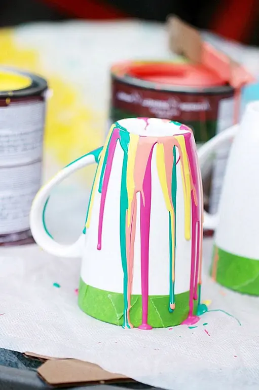 Вы также можете сделать что-то подобное для ваших кофейных кружек. Вы должны зафиксировать край обода, чтобы предотвратить попадание краски в эту область. Затем вы можете позволить капельнице по сторонам. Достаточно нескольких ударов. Ручка также может быть окрашена. Позвольте краске высохнуть, а затем удалите ленту. Вы должны вымыть эти кружки, чтобы не смыть краску посудомоечной машиной. Вы можете экспериментировать со всеми видами цветовых комбинаций, пока не достигнете результата. Идея также работает, если вы хотите предложить персонализированные кофейные кружки в подарок кому-то. {Found on frugalmomeh}