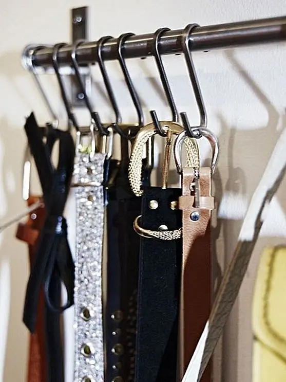 Для ваших поясов вы можете придумать очень простую систему. Вам понадобится металлический стержень и несколько крючков S. Вы можете повесить стержень в любом месте. Ваш шкаф может быть одним из вариантов, хотя вы также можете прикрепить его к стене.
