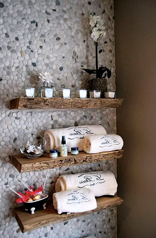 Используйте полки для журналов в сочетании с другими функциями, которые используют натуральные материалы, такие как дерево или камень. Эти полки для ванной выглядят красиво на галечной стене. Обе функции вдохновляют, и вместе они придают комнате свежий и уютный вид.
