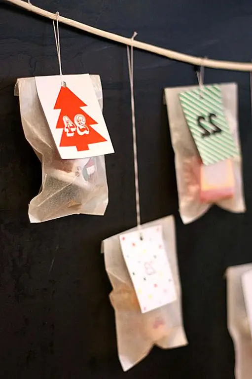 Для этого проекта вам нужны 24 конверта, 24 маленьких подарка, принтер, дырокол, шпагат или лента и простая белая бумага. Распечатывайте теги и цифры, пробивайте отверстия в каждом и повесьте их с помощью шпагата из ветки или чего-нибудь подобного. Не забудьте подарки. {Найдено на бонтоне}.