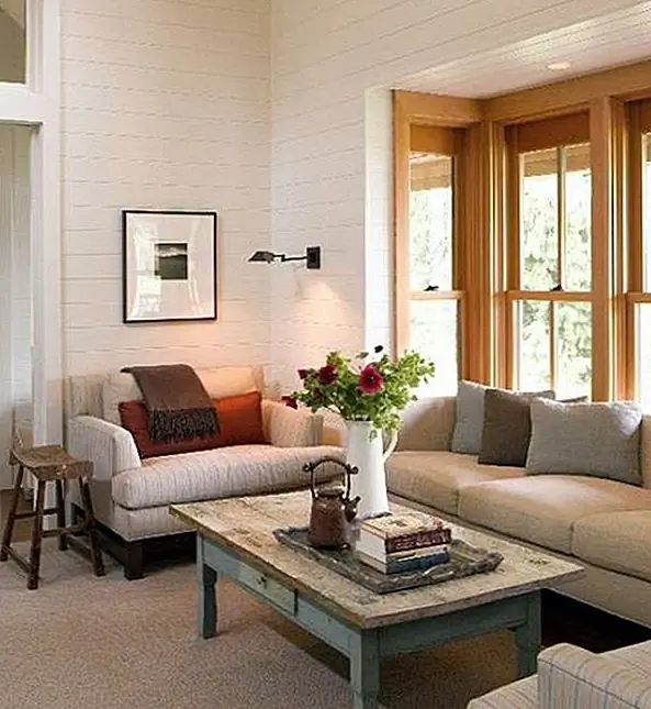 Эта гостиная определяется всеми простыми линиями, красивыми панельными белыми стенами и переделанной мебелью. Кофейный столик и стул - звезды этого декора, и они делают комнату более комфортной, очаровательной и привлекательной. Это очень интересное сочетание стилей и влияний.