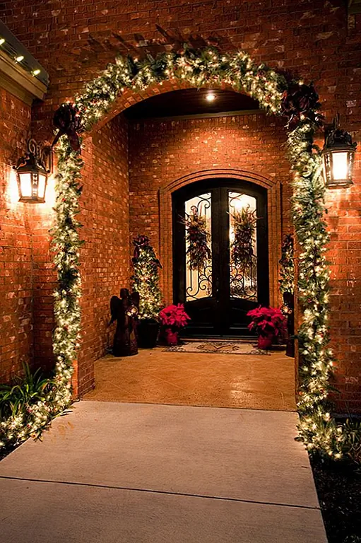Если у вас есть арочный передний вход, то украсьте его рождественскими огнями или сделайте гирлянду. Вы можете использовать гвозди и провод, чтобы связать огни и создать этот красивый декор для вашего крыльца или входа.