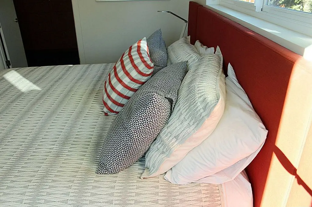 Две стандартные подушки размера king size, одна поверх другой, во главе кровати, затем перед парой устанавливается широкая и более короткая подушка контрастного цвета. Собственный «каньон» между двумя сторонами подушечных механизмов замаскирован одной брошенной подушкой в центре. Безумно красивая.