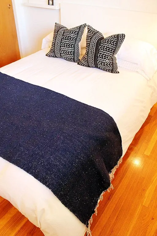 Морской бросок, сложенный просто в широком куске у подножия кровати, обеспечивает отличный визуальный контраст, а также удобное место для добавления слоя. Цвет также встроен в две тонко уложенные вниз подушки броска, аккуратно расположенные в голове кровати, что обеспечивает прекрасный баланс.