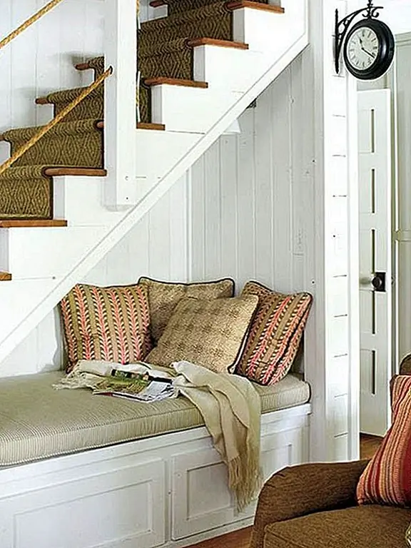 4) Сделайте уголок для чтения. Пространство под лестницей можно использовать для создания области чтения. Добавьте диван или кресло, стол и книжный шкаф. Установите осветительную арматуру, и у вас есть специальное пространство для чтения.