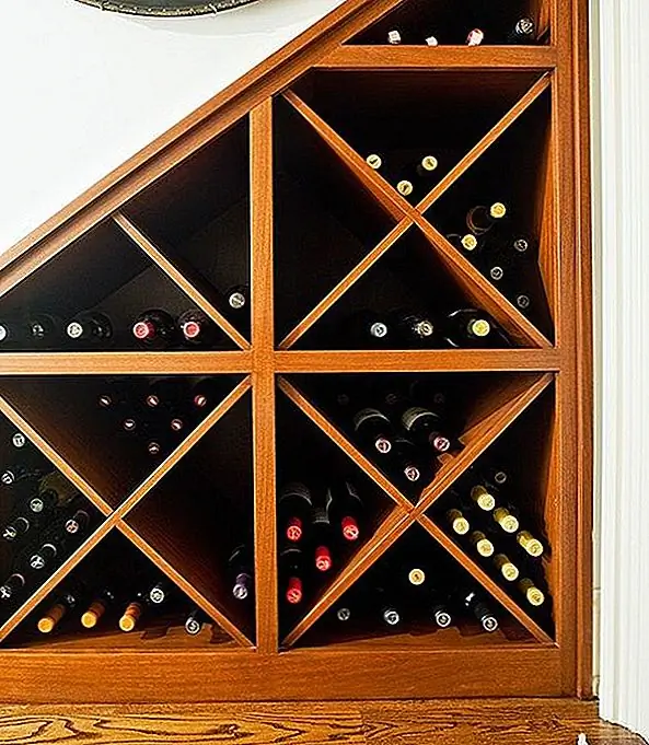 5) Винный шкаф - использование мертвого пространства под лестницей для хранения винных бутылок - просто отличная идея. Вы можете установить постоянную сборку или выбрать элегантные слайдовые стойки. Это пространство предоставит вам больше места для хранения, чем ваша мини-стойка, купленная на рынке.