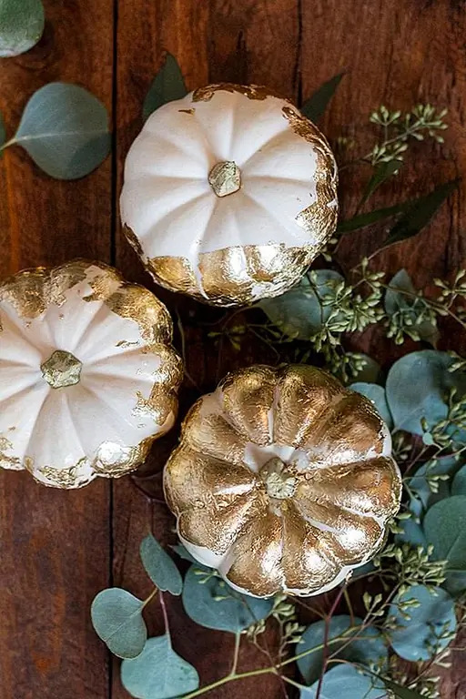 Золотой лист - это еще один многоцелевой промысел. Это выглядит особенно сногсшибательно, когда покрывает некоторые белые тыквы, подобные этому. Я вижу их как центральную фигуру на свадьбе или причудливый взрослый званый обед. (через прибрежную невесту)