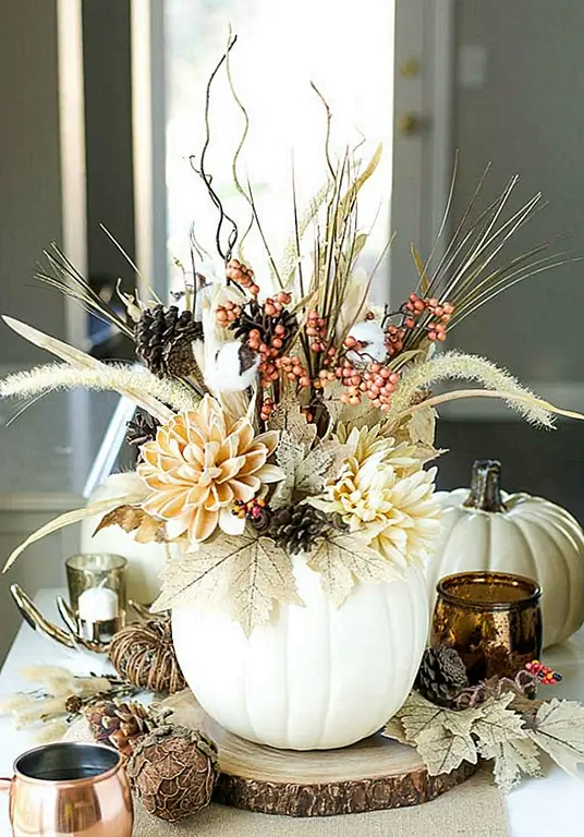 Используйте свою тыкву в качестве вазы! Вы можете использовать реальный или поддельный. В любом случае, вырежьте отверстие посередине, вставьте стеклянную вазу и заполните ее листьями и осенними цветами и травой. В конечном итоге это станет вашим самым красивым центральным элементом. (через А тыкву и принцессу)