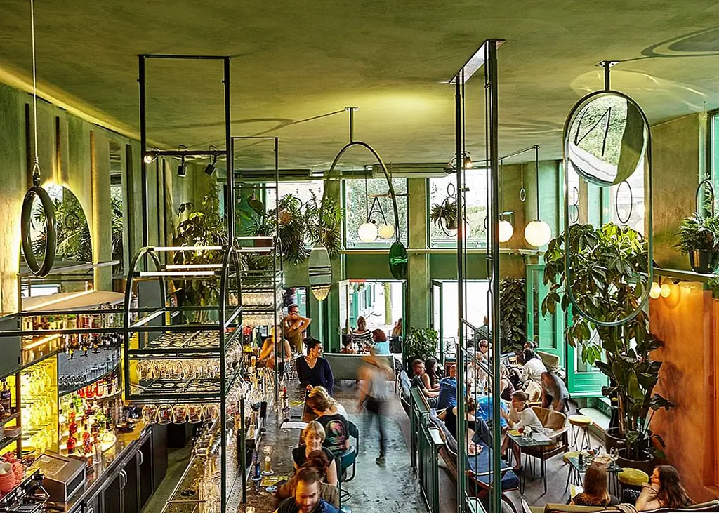 В этой композиции играют свою роль пальмы, папоротники и другие тропические растения. Они лежат в основе дизайна, не делая другие элементы менее важными. Ничего не было упущено в процессе, даже логотип бара, который красиво обертывается вокруг фасада, украшает верхние окна.