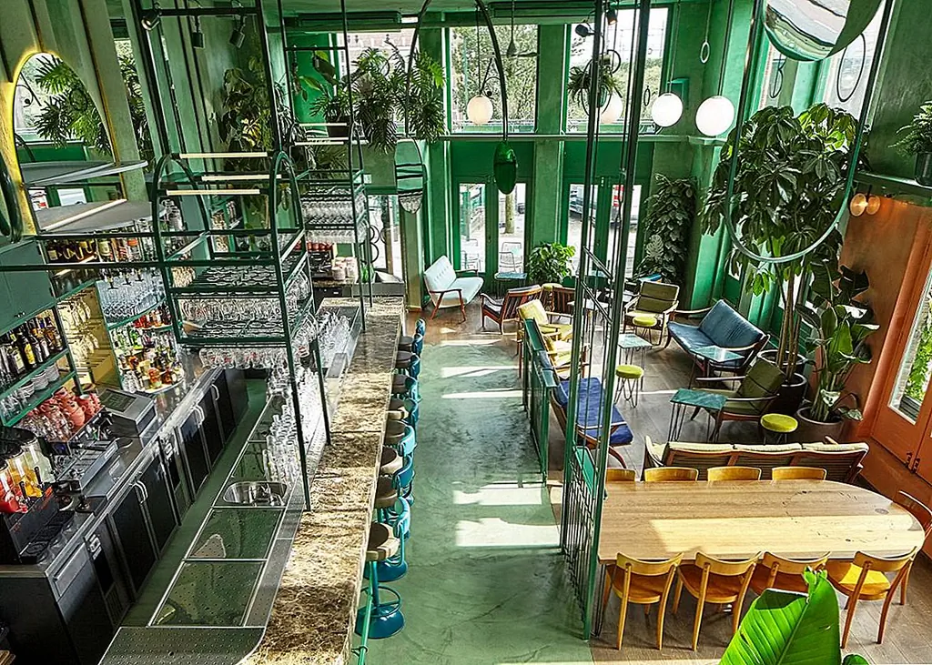 Это удивительное ботаническое кафе и бар обязано своим уникальным характером множеству элементов. Например, структура здания и его дизайн делают пространство похожим на оранжерею. С двухслойным остеклением с двух сторон интерьер наполнен естественным светом, который позволяет растениям процветать.