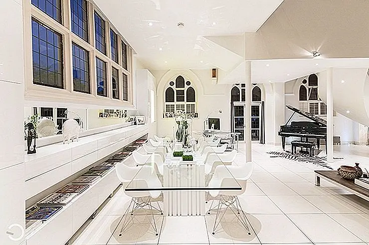 Сопоставление стилей также становится более заметным в столовой, где гладкий белый стол со стеклянным верхом и арочными дверными проемами представляет интересную и элегантную смесь.